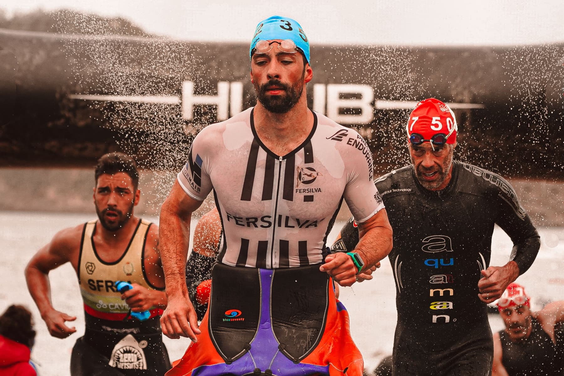 Triathletes running out of the swim during a race